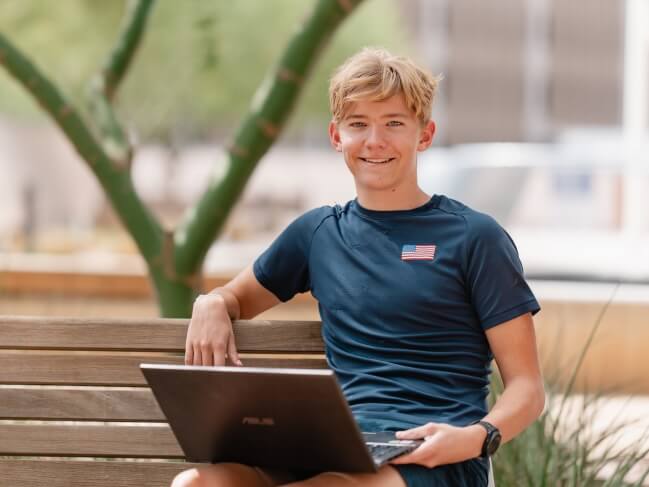 Student on laptop in park