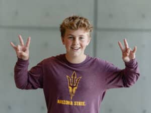 ASU student holding up the ASU hand sign