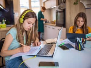 Students learning virtually with parent doing chores