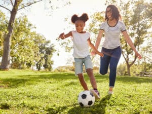 Student and parent playing soccer