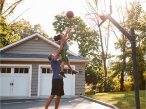 Student and parent playing basketball